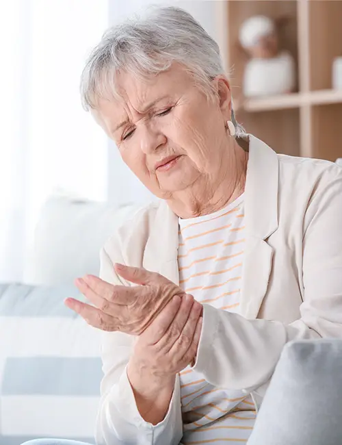 Photo of a woman holding her hand in pain.